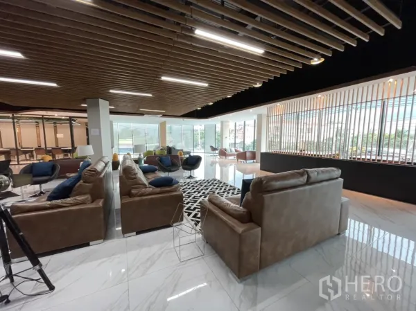 สำนักงาน ให้เช่าในLam Luk Ka, Pathum Thani - ล็อบบี้กว้าง โซฟาหนัง พื้นกระเบื้องลายหินอ่อน ฝ้าไม้ระแนง และกระจกเต็มบานรับแสงธรรมชาติ