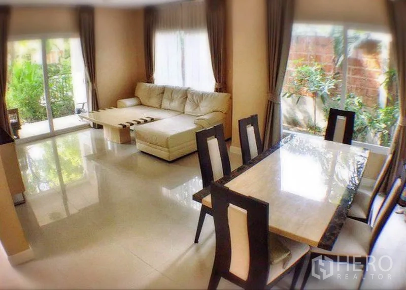 บ้าน ให้เช่าหรือขายในBang Yai, Nonthaburi - พื้นที่นั่งเล่นและรับประทานอาหารแบบเปิด โซฟามุม หน้าต่างบานใหญ่ และวิวสวน