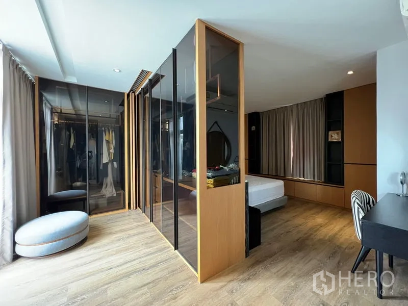 联排别墅 出租在Saphan Sung, Bangkok - 大型主卧更衣室，玻璃衣柜分隔睡眠区。