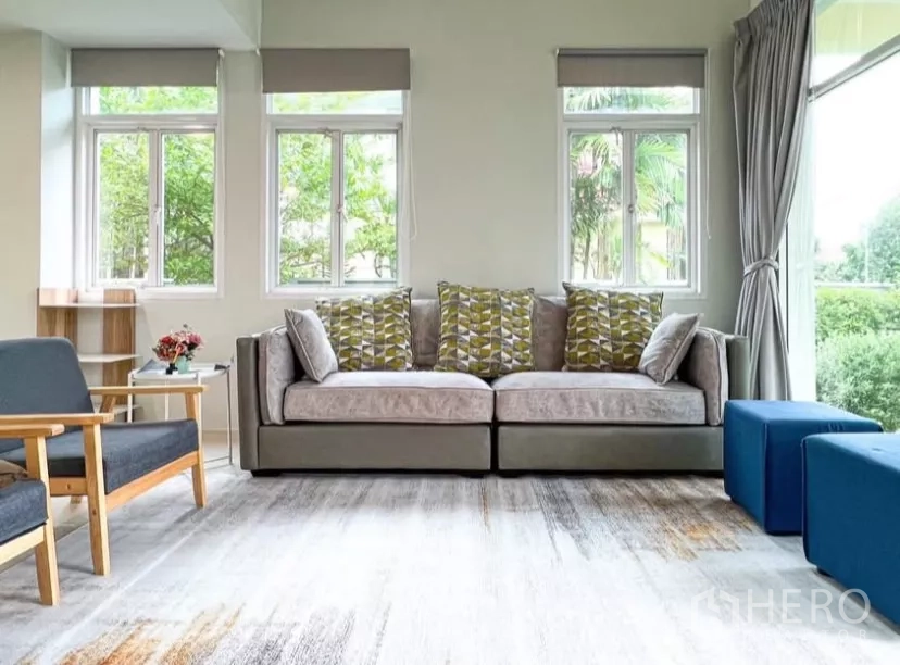 Detached House for rent or sale in Prawet, Bangkok - Sofa-focused living room with triple windows and garden outlook.