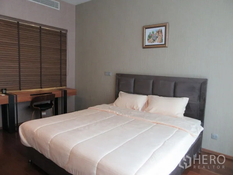 公寓 出租或出售在Watthana, Bangkok - 主卧设大床、窗边书桌与木质百叶窗。