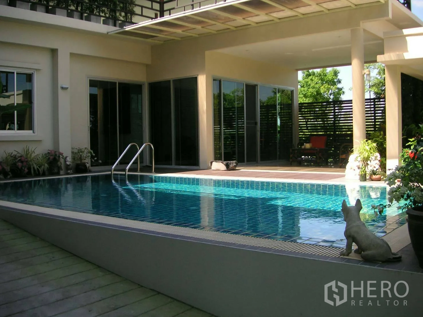 Detached House for rent or sale in Prawet, Bangkok - Private swimming pool beside a covered terrace and wide sliding glass doors.