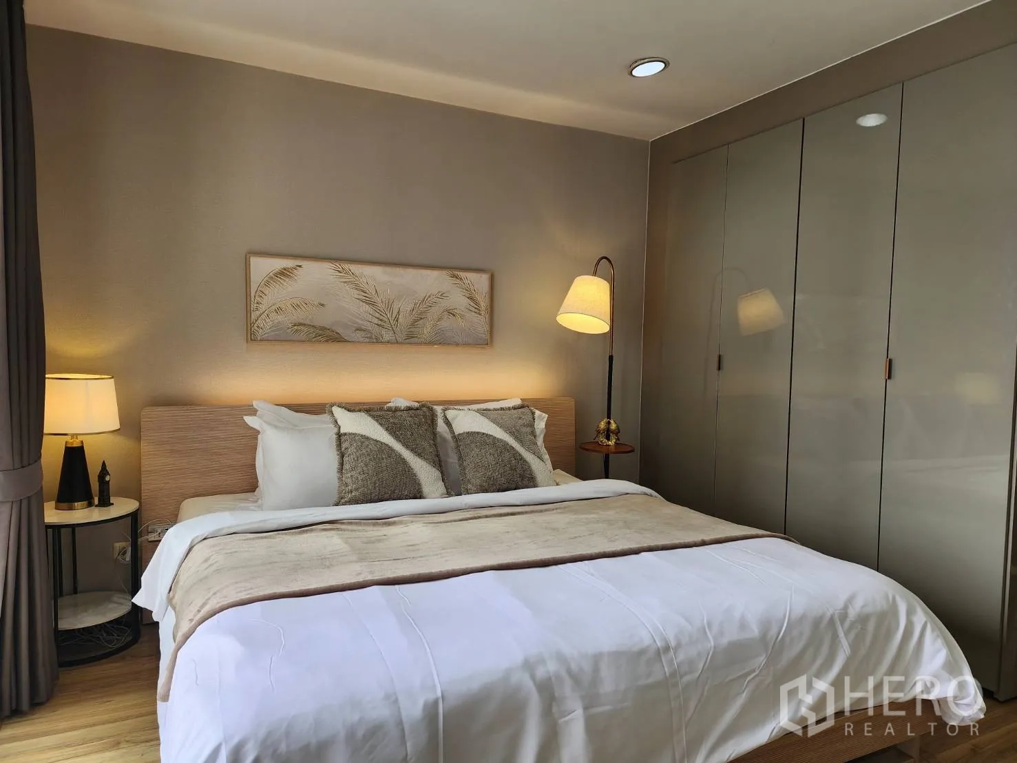Condominium for rent in Watthana, Bangkok - Primary bedroom with king bed, bedside lamps and glossy built-in wardrobes.