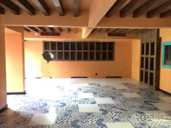 零售空间 出租在Khlong Toei, Bangkok - 开放式零售室内，蓝白花砖地面、橙色墙面、裸露木梁以及一排长窗。