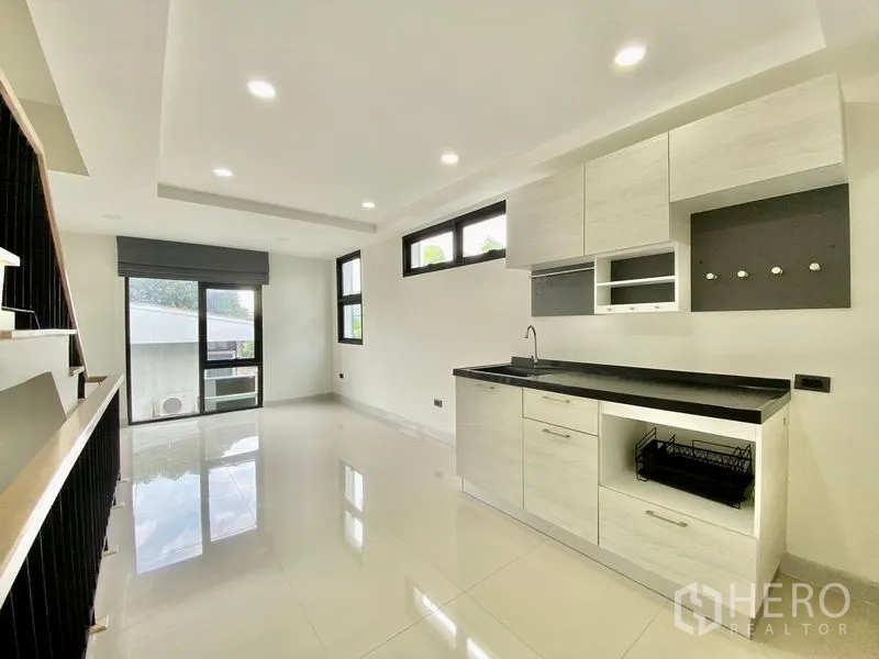 Home Office for rent or sale in Bang Na, Bangkok - Bright kitchen and dining zone with built-in cabinets, multiple windows and access to a balcony.