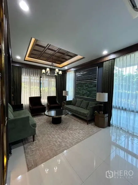 独立式住宅 出租在Bang Kapi, Bangkok - 典雅客厅，格栅天花与吊灯，落地窗和舒适沙发。