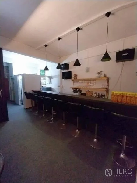 店屋 出租在Khlong Toei, Bangkok - 白墙室内的整面长吧台与多把吧椅。