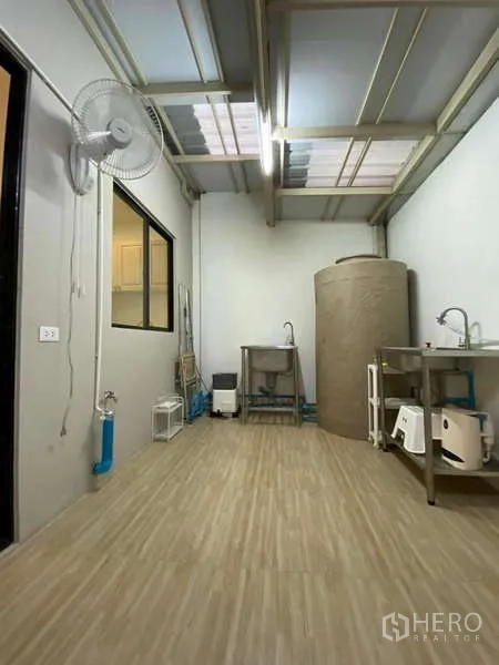 Townhouse for rent in Bang Kapi, Bangkok - Covered rear utility or laundry area with stainless sinks, water tank and fan.