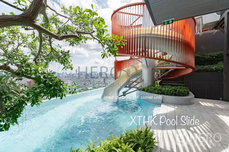 Condominium for rent or sale - Rooftop infinity pool with spiral slide and panoramic Bangkok city view.