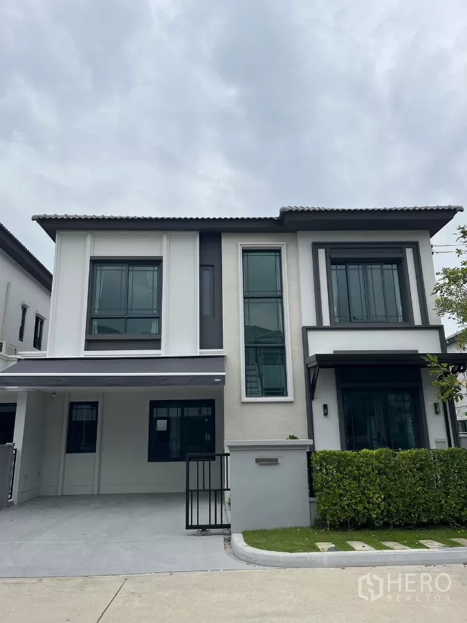 Detached House for rent or sale in Bang Phli, Samut Prakan - Modern two-storey detached house facade with large windows and a covered carport in a gated community.