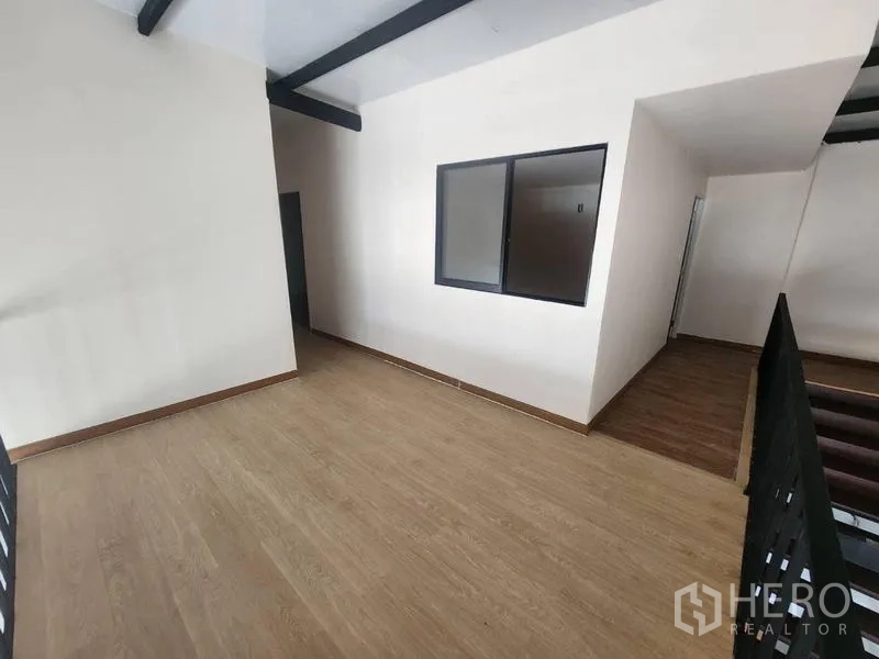 Warehouse for rent in Suan Luang, Bangkok - Open mezzanine workspace with wood flooring and an interior window.