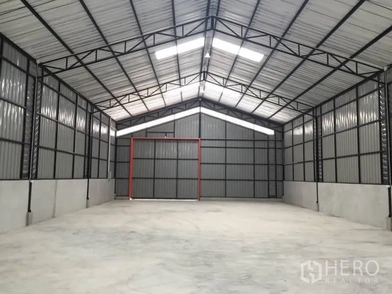 Warehouse for rent in Lat Phrao, Bangkok - Open-plan warehouse interior with high gable roof, skylights, and concrete floor.
