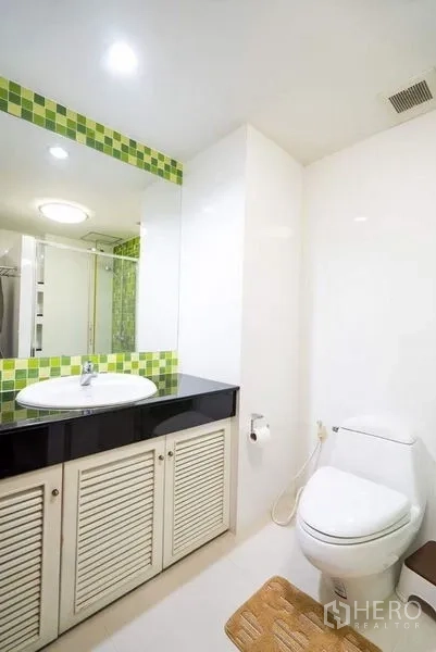 公寓 出租或出售在Bang Phlat, Bangkok - 卫生间设长台面、黑色台面、大镜子与坐便器。