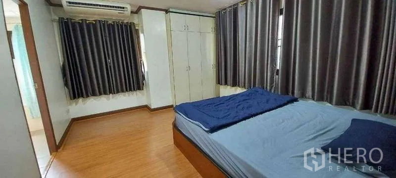 คอนโด ให้เช่าในKhlong Toei, Bangkok - ห้องนอนหลักพื้นไม้ ตู้เสื้อผ้าบิวท์อิน เตียงขนาดใหญ่ ม่านทึบ และเครื่องปรับอากาศ