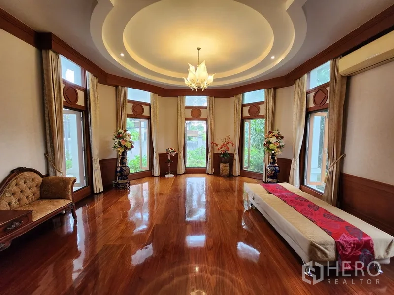 独立式住宅 出租在Prawet, Bangkok - 大面积飘窗会客厅，圆形吊顶与高光实木地板。