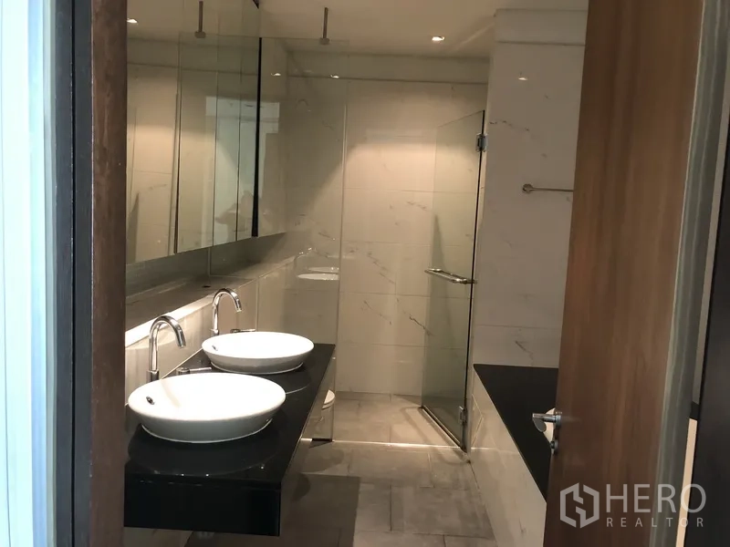 คอนโด ให้เช่าในKhlong Toei, Bangkok - ห้องน้ำสมัยใหม่ อ่างล้างหน้าคู่ กระจกบานใหญ่ และตู้ฝักบัวกระจก