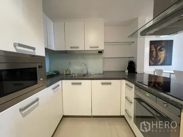 คอนโด ให้เช่าหรือขายในWatthana, Bangkok - ครัวรูปตัว U ตู้สีขาว เคาน์เตอร์หิน เตาอบ เตาไฟฟ้า และอ่างล้างจาน.