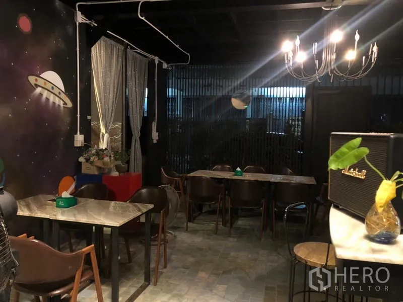 พื้นที่ขายปลีก ให้เช่าในKhlong Toei, Bangkok - โซนรับประทานสไตล์คาเฟ่ โคมไฟแชนเดอเลียร์ และกำแพงลายอวกาศ