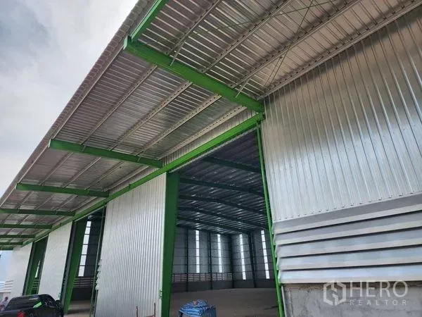 货栈 出租在Wang Noi, Phra Nakhon Si Ayutthaya - 打开的滑门展现仓库入口处的钢结构与雨棚。