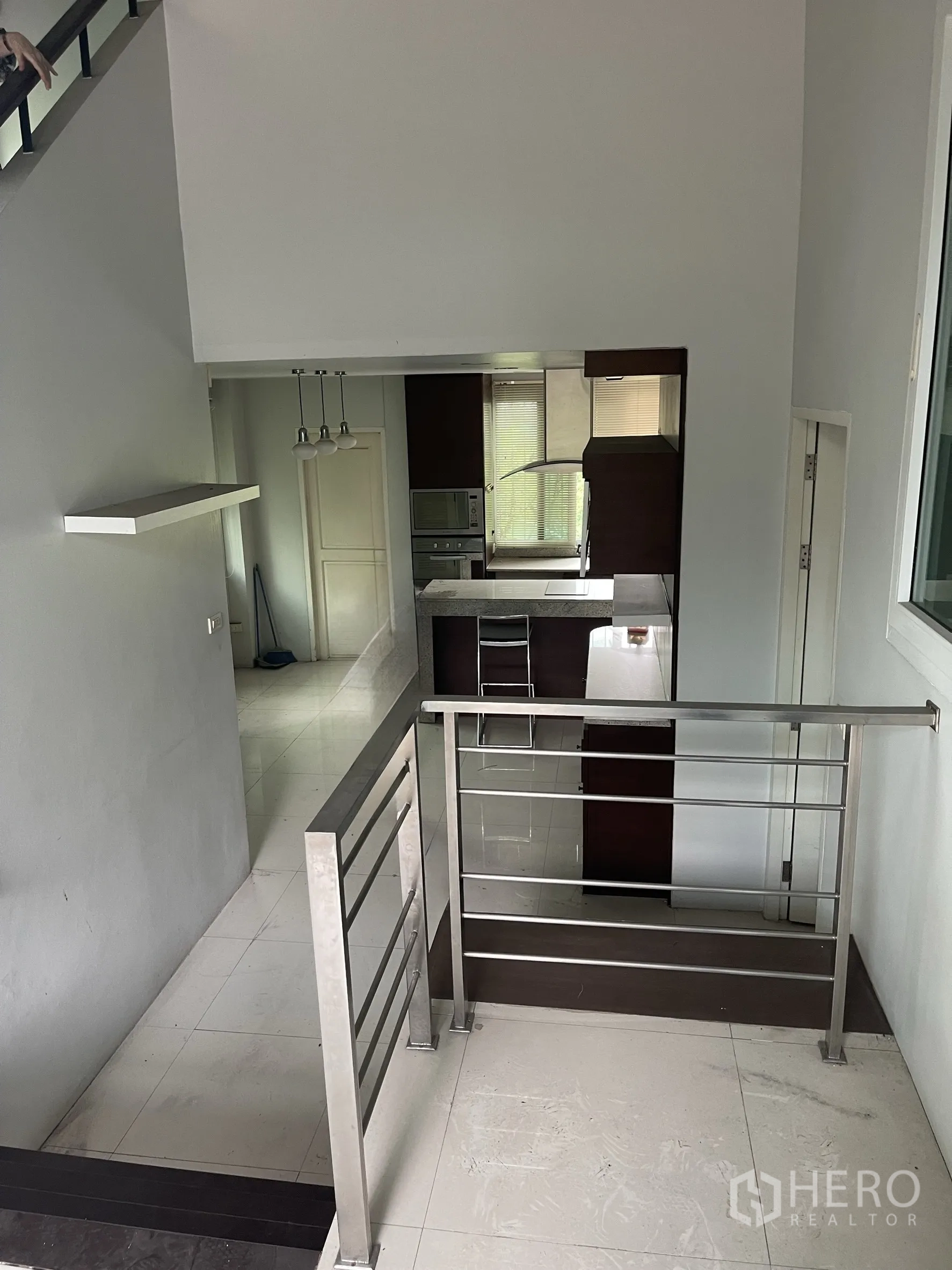 带办公室的家 出租在Wang Thonglang, Bangkok - 夹层平台俯瞰厨房，不锈钢栏杆与地砖