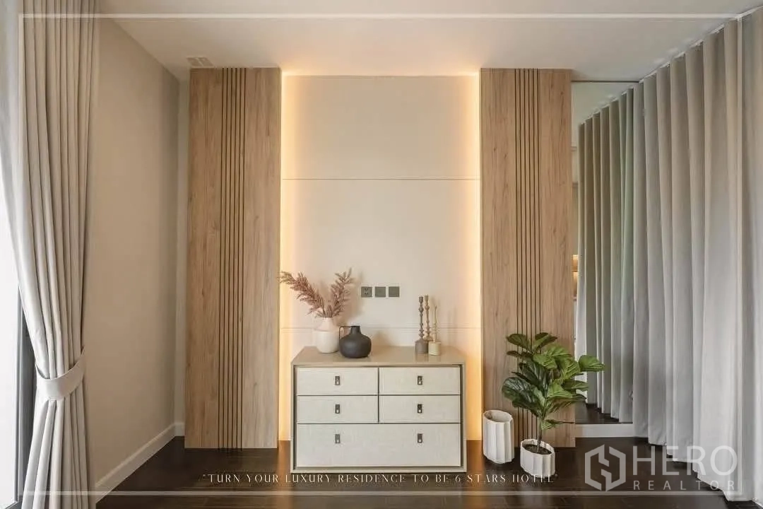 Detached House for rent or sale in Suan Luang, Bangkok - Accent wall with warm backlighting, chest of drawers and indoor plants.