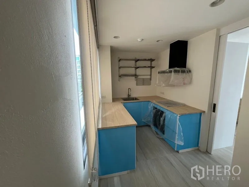 ทาวน์เฮาส์ ให้เช่าในKhlong Toei, Bangkok - ครัวรูปตัวแอลพร้อมเคาน์เตอร์ไม้ ช่องแสง และเครื่องดูดควัน