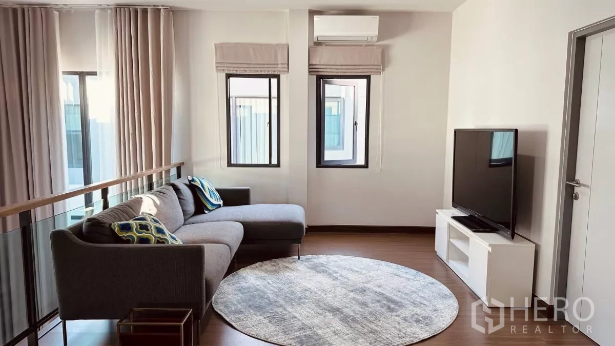 Detached House for rent in Bang Phli, Samut Prakan - Family room with TV setup and a round rug under natural light.