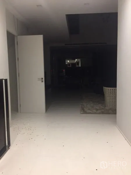 独立式住宅 出租在Wang Thonglang, Bangkok - 宽敞走廊，白色地砖与开启的房门通向起居区。