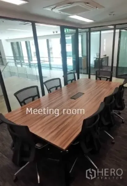 Office Space for rent in Khlong Toei, Bangkok - Glass-walled meeting room with long wood conference table and mesh chairs in a modern office.