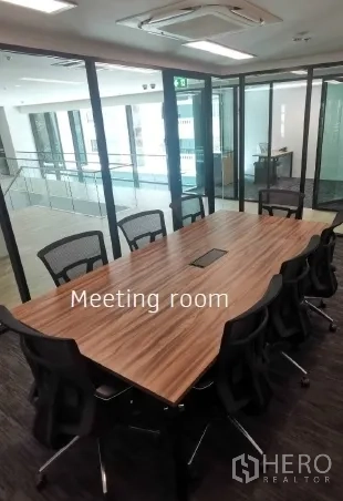 Office Space for rent in Khlong Toei, Bangkok - Glass-walled meeting room with long wood conference table and mesh chairs in a modern office.