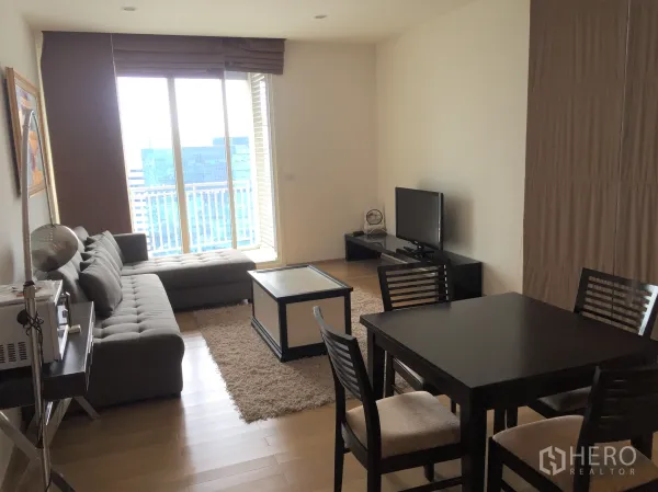 คอนโด ให้เช่าในWatthana, Bangkok - ห้องนั่งเล่นสว่าง โซฟา ชั้นวางทีวี และหน้าต่างสูงเต็มบานพร้อมวิวเมือง