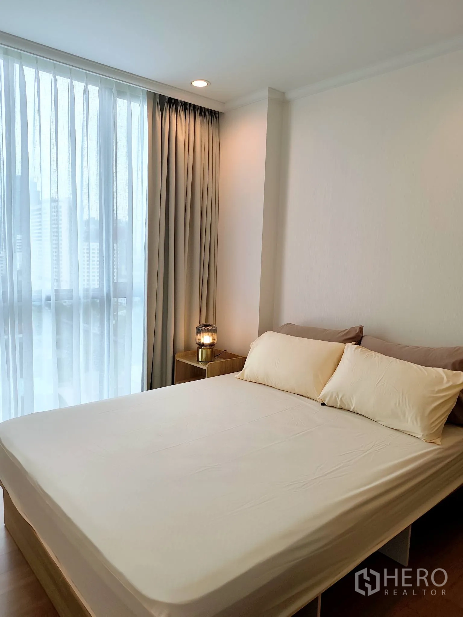 公寓 for rent in Watthana, Bangkok - 采光充足的卧室，配大床、床头柜与落地窗帘，可赏城市景观。