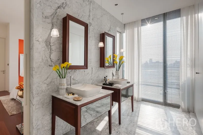 Condominium for sale in Watthana, Bangkok - Bright bathroom with marble walls, double vanity and large window letting in natural light.