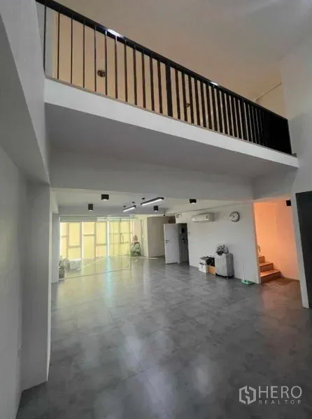 สำนักงานที่บ้าน ขายในPhra Khanong, Bangkok - โถงทำงานเพดานสูงแบบดับเบิลวอลุ่ม พร้อมชั้นลอย พื้นกระเบื้องสีเทาและผนังกระจกเต็มบาน