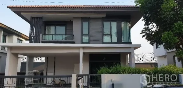 独立式住宅 出租或出售在Lam Luk Ka, Pathum Thani - 两层现代独栋外立面，带阳台、车棚与前花园。