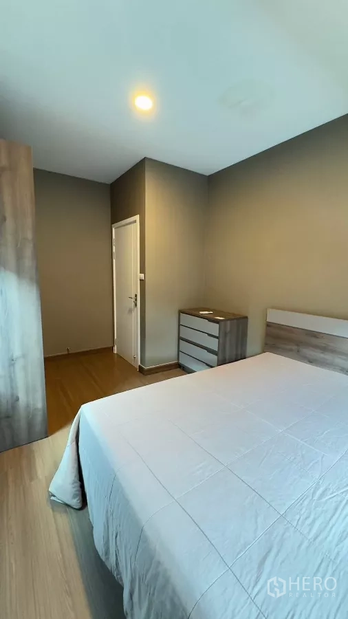 独立式住宅 出租在Samut Prakan - 次卧以中性色调布置，带衣柜与斗柜。