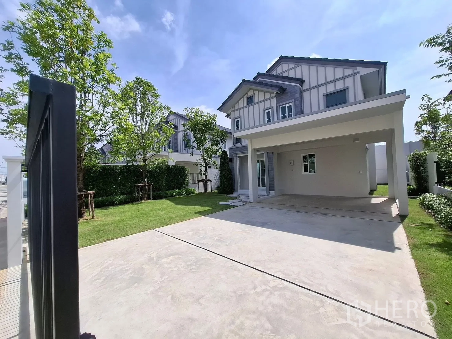 Detached House for rent in Bang Phli, Samut Prakan - Modern detached house exterior with covered carport, driveway and lawn.