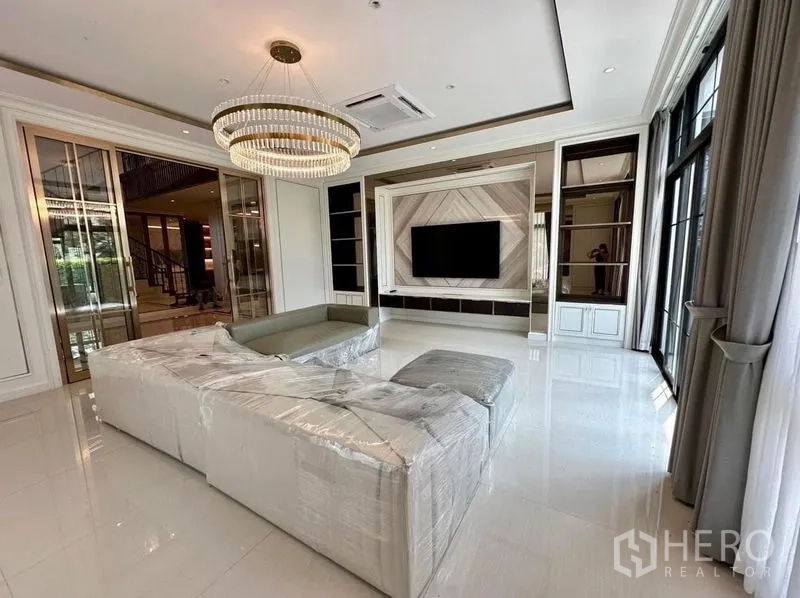 Detached House for sale - Another angle of the light-filled living room with wrapped sectional and chandelier.