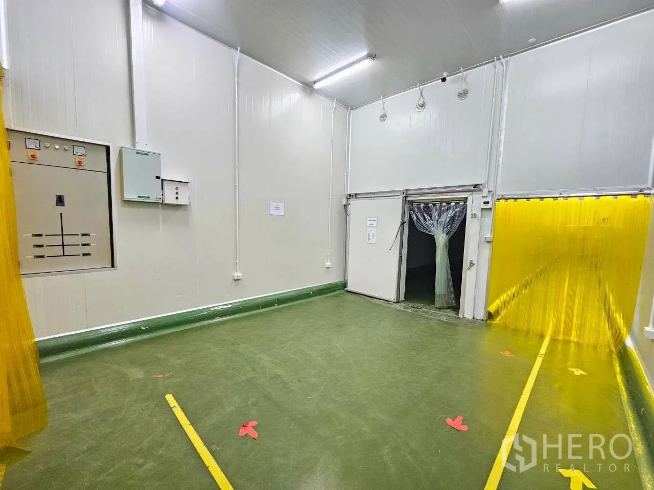 工厂 for rent in Mueang Samut Sakhon, Samut Sakhon - 绿色地面的前室，带控制面板与两道保温门。