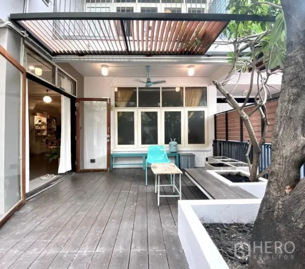 ทาวน์เฮาส์ ให้เช่าในKhlong Toei, Bangkok - ชานหน้าบ้านปูไม้ มีหลังคาระแนง พัดลมเพดาน ม้านั่งและกระบะปลูกต้นไม้