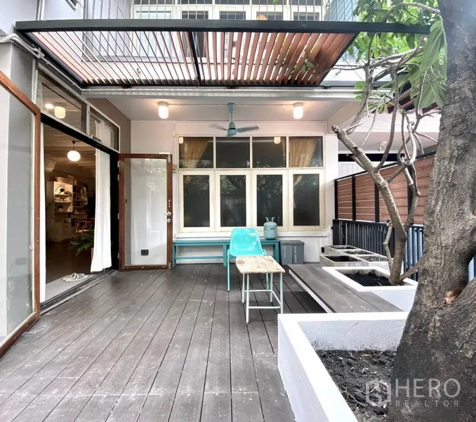 ทาวน์เฮาส์ ให้เช่าในKhlong Toei, Bangkok - ชานหน้าบ้านปูไม้ มีหลังคาระแนง พัดลมเพดาน ม้านั่งและกระบะปลูกต้นไม้