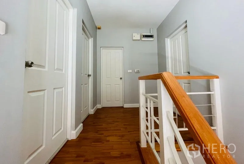 บ้าน ขายในLam Luk Ka, Pathum Thani - โถงชั้นบน บันไดไม้ พื้นไม้ และประตูสีขาวรอบด้าน