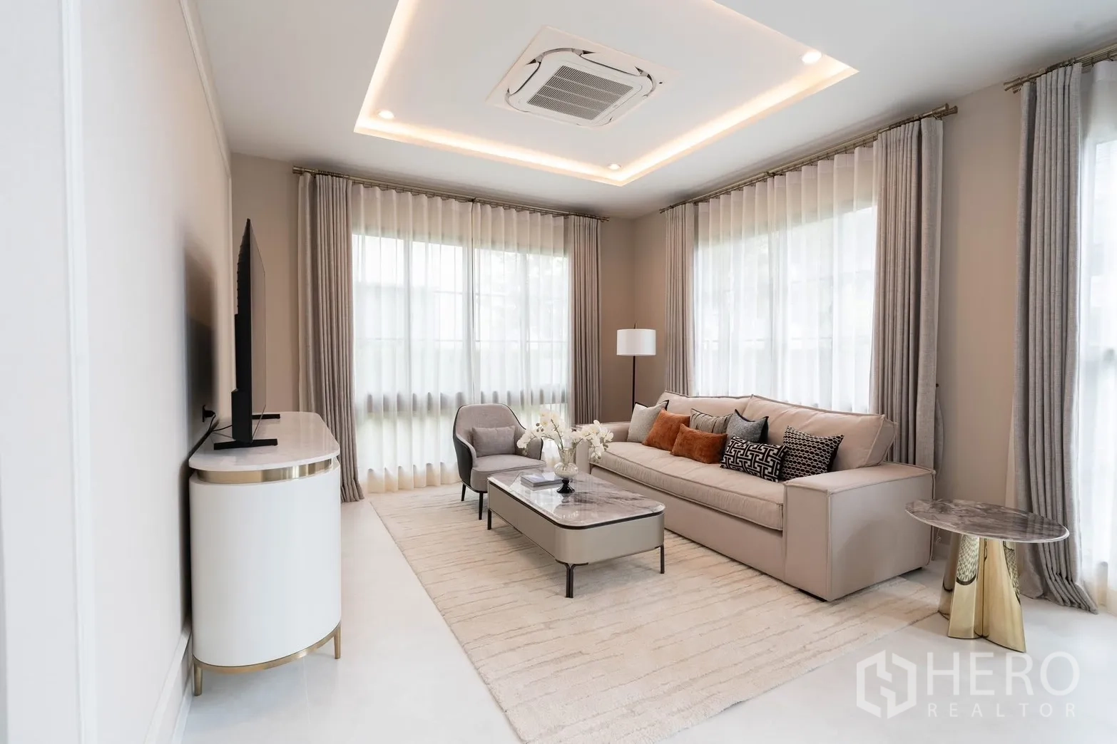 Detached House for rent in Bang Phli, Samut Prakan - Elegant living room with cove lighting, sofa set, coffee table, and TV.