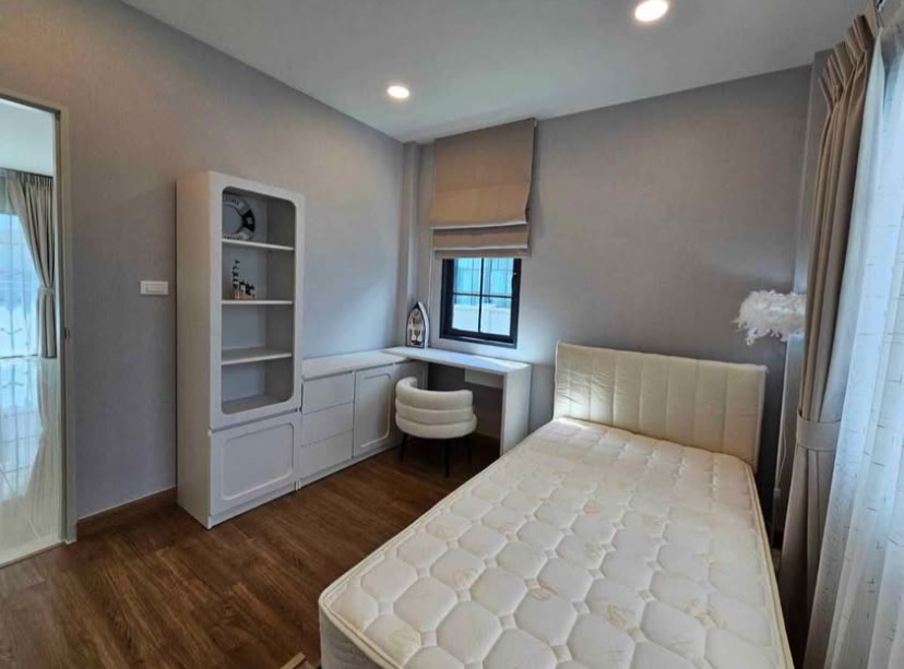 Detached House for rent in Bang Phli, Samut Prakan - Cozy bedroom with single bed, built‑in desk and shelving, wood floors and window blinds.