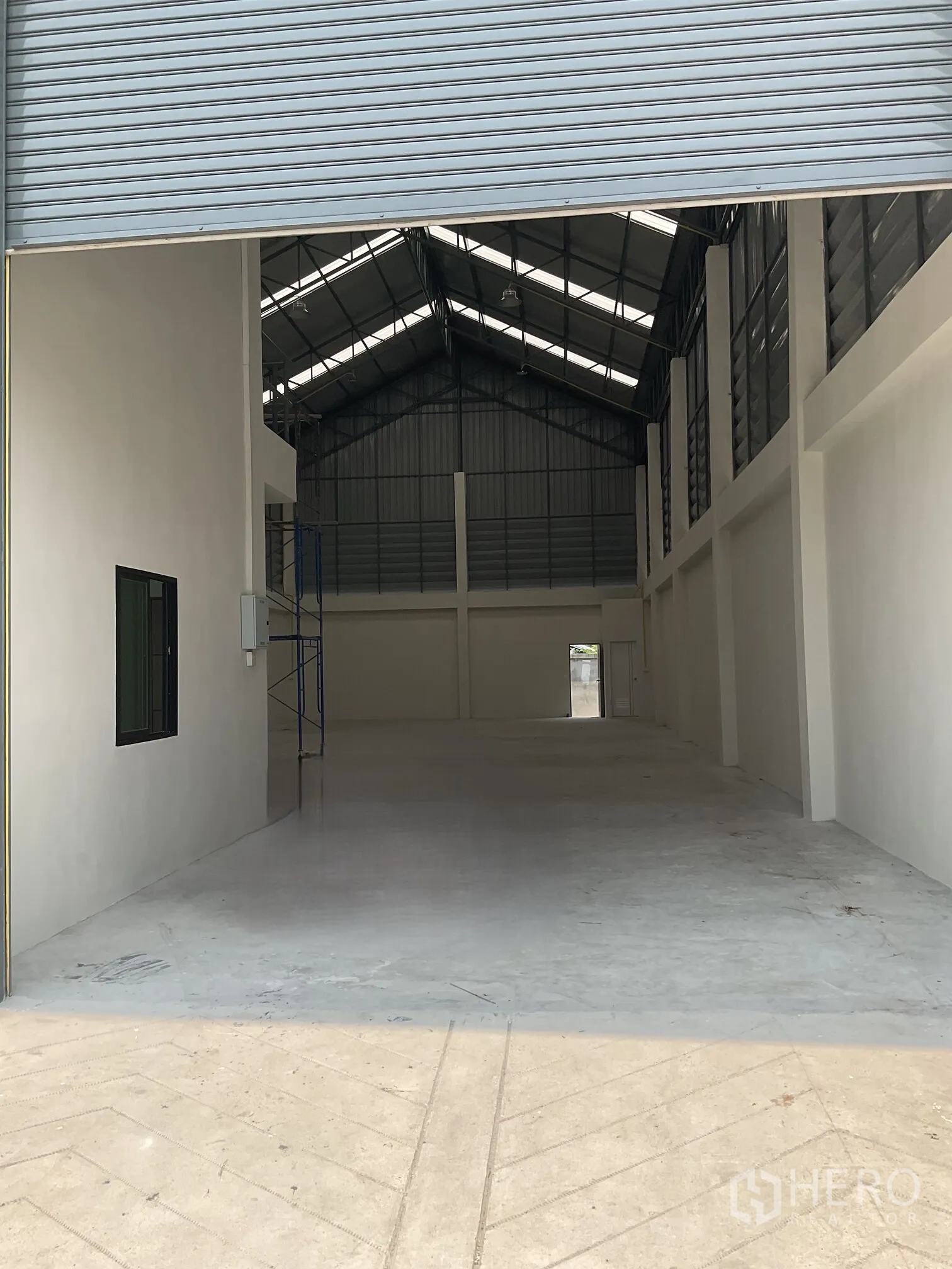 โกดัง for rent in Lat Lum Kaeo, Pathum Thani - ภายในโกดังโล่ง หลังคาทรงจั่วสูง พื้นคอนกรีต และมีออฟฟิศชั้นลอยใกล้ทางเข้า