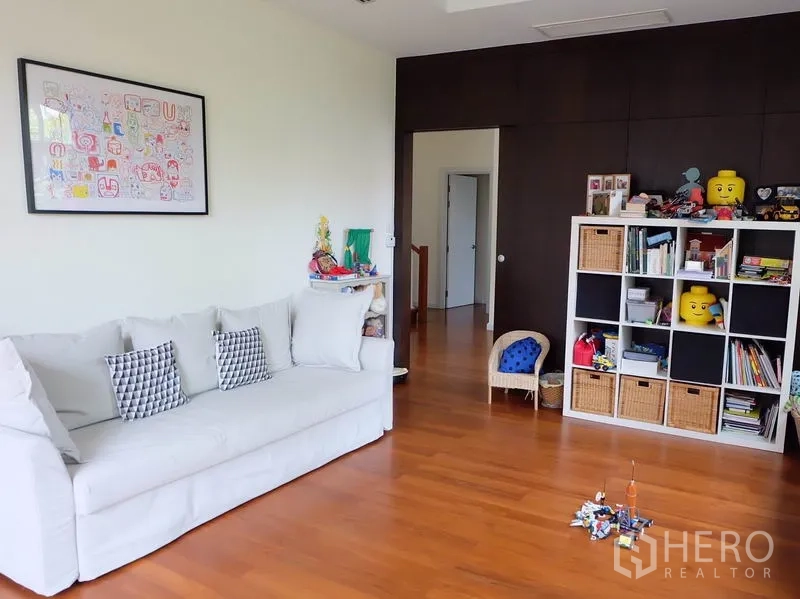 Detached House for rent in Watthana, Bangkok - Upstairs lounge with a white sofa and cube shelving unit for books and toys.