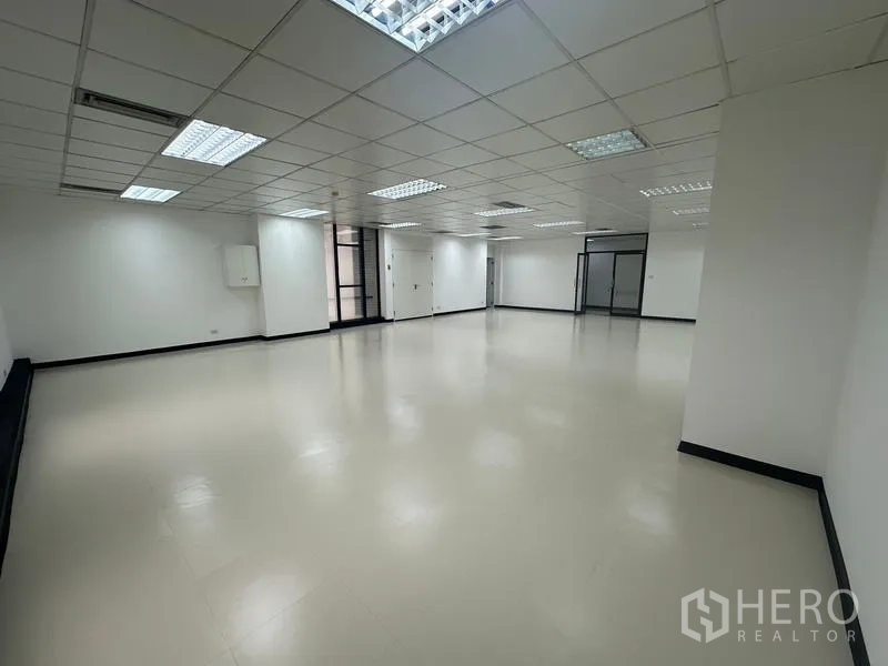 สำนักงาน ให้เช่า - มุมมองภายในเห็นประตูกระจกทางเข้า ฉากกั้นกระจก พื้นเรียบ และไฟฝ้าในตัว