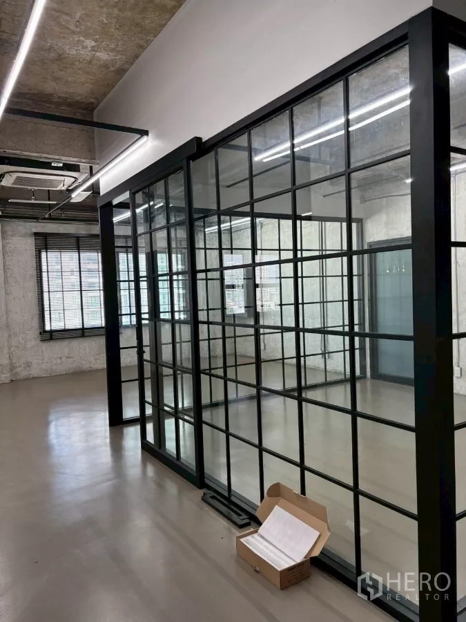 Office Space for rent in Watthana, Bangkok - Close-up of black-framed glass walls forming a compact meeting room under LED lighting.