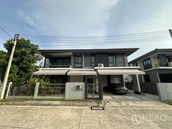 独立式住宅 出租或出售在Lam Luk Ka, Pathum Thani - 位于Lam Luk Ka的现代两层独栋别墅，带围栏大门、条纹遮阳篷与双车位车棚，临安静街道。