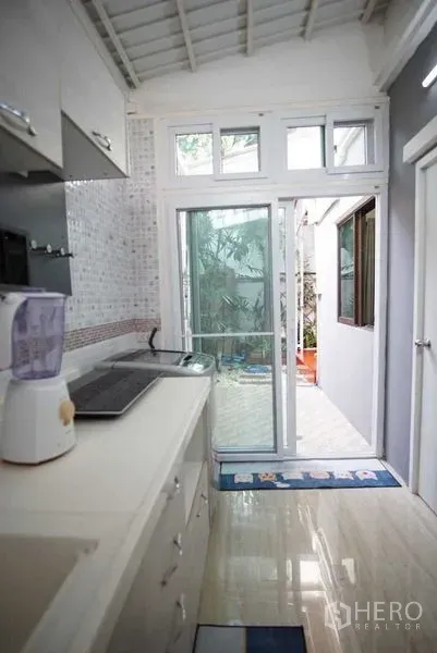 ทาวน์เฮาส์ ให้เช่าในSuan Luang, Bangkok - มุมครัวเชื่อมประตูกระจกบานเลื่อนออกสู่ลานเล็กมีต้นไม้